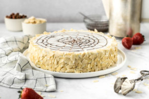 Festliches Rezept für klassische ungarische Esterházy Torte. Zarte Haselnuss Böden aus süßer Makronenmasse mit aromatischer Vanille Buttercreme. Dekoriert mit Mandelblättchen. Glutenfreie Torte ohne Mehl. #Esterházy #Geburtstagstorte #Esterházyschnitte #Esterházytorte #glutenfrei #torteohnemehl #Haselnusstorte #nusstorte #buttercreme #buttercremetorte