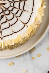 Festliches Rezept für klassische ungarische Esterházy Torte. Zarte Haselnuss Böden aus süßer Makronenmasse mit aromatischer Vanille Buttercreme. Dekoriert mit Mandelblättchen. Glutenfreie Torte ohne Mehl. #Esterházy #Geburtstagstorte #Esterházyschnitte #Esterházytorte #glutenfrei #torteohnemehl #Haselnusstorte #nusstorte #buttercreme #buttercremetorte