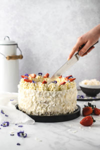 Rezept für festliche Erdbeer Kokos Torte mit Mascarpone. Getränkt mit Kokosmilch und dekoriert mit essbaren Blüten. Super schön dekorierte sommerliche Torte, perfekt als Geburtstagstorte! #Erdbeer #Kokos #Torte #Dekoration #Tortendekoration #Erdbeeren #Geburtstagstorte