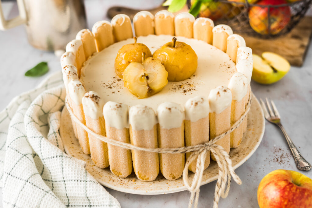 Einfaches Rezept zum backen einer Apfeltorte mit selbstgemachtem Apfelkompott, Vanillemousse Creme auf Puddingbasis (ohne Gelatine) und eleganter Dekoration aus Löffelbiskuit im Charlotte Torte Stil und pochierten Äpfeln. Diese einfache Apfeltorte solltet ihr im Herbst unbedingt machen! #Apfeltorte #Apfelkuchen #saisonal #Charlotte #backen #Rezept