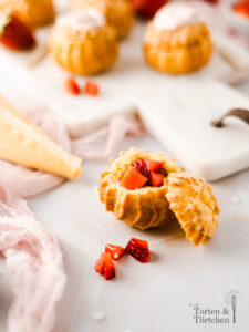 Außen knusprig innen cremig! Diese süßen Mini Windbeutel sind gefüllt mit Vanillepudding und frischen Erdbeerstückchen. Die Choux werden aus Brandteig gemacht, aber keine Sorge, mit diesem Rezept sollte euch auch dieser gelingen! Die Erdbeer Vanille Choux sind perfekt für die Kaffeetafel oder zum Mitnehmen fürs Büro. #Windbeutel #Erdbeeren #Backen #Rezept #Brandteig #Choux