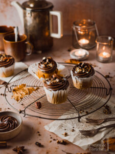 Ein einfaches Rezept für herbstliche Pumpkin Spice Cupcakes mit gebrannten Pekannüssen. Die karamellisierten Nüsse auf einer reichen Schokoadencreme passen einfach so gut zu dem gewürzten saftigen Kürbismuffin! #Pumpkinspice #backen #Rezept #Kürbis #Herbstrezepte #Nüsse #Muffins #Cupcakes