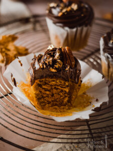Ein einfaches Rezept für herbstliche Pumpkin Spice Cupcakes mit gebrannten Pekannüssen. Die karamellisierten Nüsse auf einer reichen Schokoadencreme passen einfach so gut zu dem gewürzten saftigen Kürbismuffin! #Pumpkinspice #backen #Rezept #Kürbis #Herbstrezepte #Nüsse #Muffins #Cupcakes