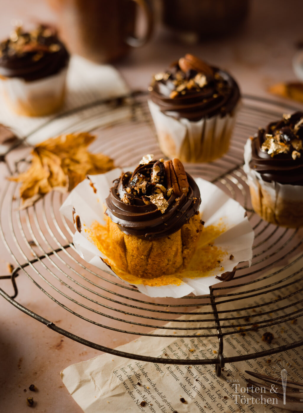 Ein einfaches Rezept für herbstliche Pumpkin Spice Cupcakes mit gebrannten Pekannüssen. Die karamellisierten Nüsse auf einer reichen Schokoadencreme passen einfach so gut zu dem gewürzten saftigen Kürbismuffin! #Pumpkinspice #backen #Rezept #Kürbis #Herbstrezepte #Nüsse #Muffins #Cupcakes