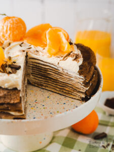 Wenn ihr euch eine Torte mit hauchdünnen, zarten Böden und einer sahnigen Creme dazwischen vorstellt, dürfte euch wohl etwas ähnliches wie eine Crepe Torte in den Sinn kommen. Weiche chewy Schokoladencrepes durchzogen von einer Mascarpone Orangen Creme und einer herben Schokoladen Ganache, einfach perfekt! Auch für alle die keinen Ofen haben und daher mal eine No Bake Torte auf den Tisch bringen möchten. #Crepetorte #Schokoladentorte #Schokotorte #Crepes #backen #rezept #vegetarisch