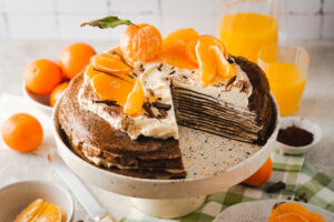Wenn ihr euch eine Torte mit hauchdünnen, zarten Böden und einer sahnigen Creme dazwischen vorstellt, dürfte euch wohl etwas ähnliches wie eine Crepe Torte in den Sinn kommen. Weiche chewy Schokoladencrepes durchzogen von einer Mascarpone Orangen Creme und einer herben Schokoladen Ganache, einfach perfekt! Auch für alle die keinen Ofen haben und daher mal eine No Bake Torte auf den Tisch bringen möchten. #Crepetorte #Schokoladentorte #Schokotorte #Crepes #backen #rezept #vegetarisch