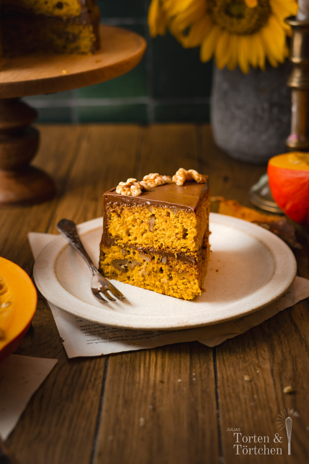 Ein einfaches Rezept für einen herbstlichen rustikalen mit Zimt, Muskat und Orange gewürzten Kürbiskuchen verfeinert mit Nüssen und mit einer samtigen herben Schokoladenganache, die die Zimtnoten der Pumpkin Spice Böden perfekt komplementiert. #herbstkuchen #herbstrezepte #pumpkinspice #kürbis #rezepte #backen