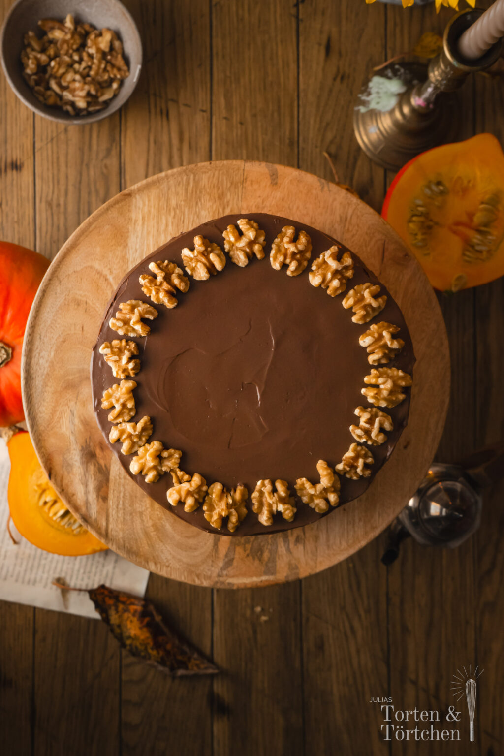 Ein einfaches Rezept für einen herbstlichen rustikalen mit Zimt, Muskat und Orange gewürzten Kürbiskuchen verfeinert mit Nüssen und mit einer samtigen herben Schokoladenganache, die die Zimtnoten der Pumpkin Spice Böden perfekt komplementiert. #herbstkuchen #herbstrezepte #pumpkinspice #kürbis #rezepte #backen