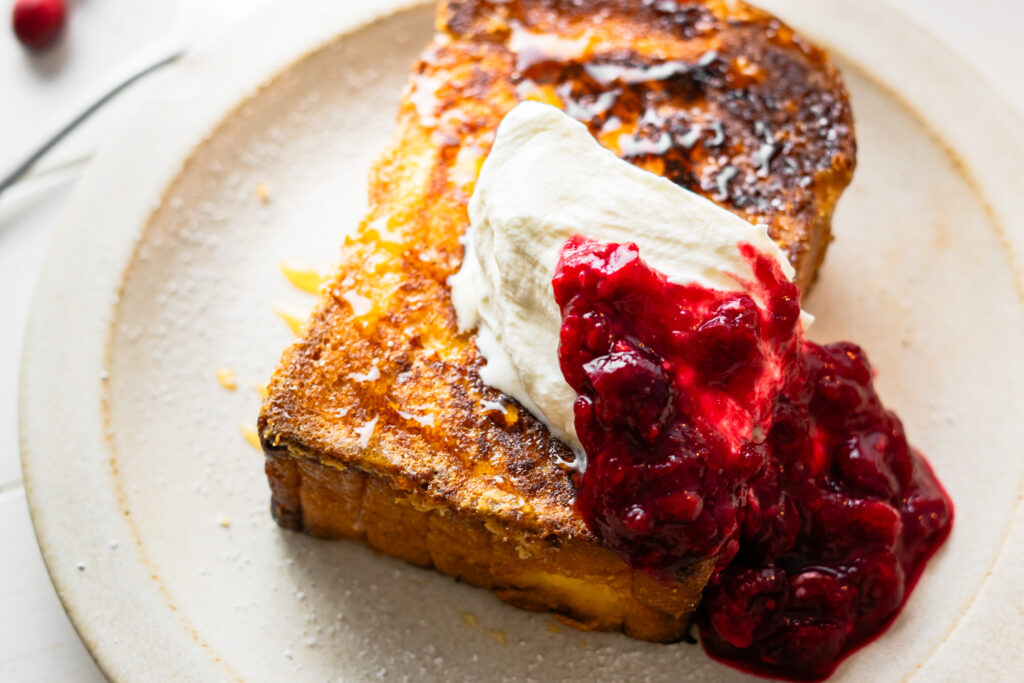 Das beste Rezept für French Toast! Schön fluffig und saftig von innen und knusprig karamellisiert von außen, dazu verfeinert mit Zimt und Muskatnuss und serviert mit samtiger geschlagener Sahne und einem winterlichen Cranberry Kompott.Perfekt für einen Hygge Weihnachtsmorgen! #Frühstücksrezepte #FrenchToast #Weihnachtsrezepte #brunchrezepte #Frühstück #Weihnachtsbrunch
