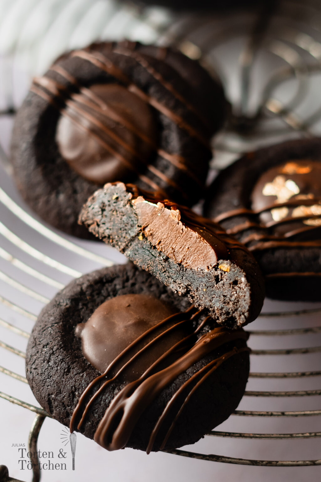 Diese Schoko-Orangen Thumbprint Cookies vereinen feine Zartbitterschokolade mit der fruchtigen Frische kandierter Orangenschalen. Gefüllt mit einer cremigen Ganache und dekoriert mit edler Schokolade sind sie ein Highlight für jeden Plätzchenteller und perfekt für die Weihnachtszeit. Einfach in der Zubereitung und beeindruckend im Geschmack – diese Plätzchen sind ein Muss für alle Schokoladenliebhaber! #Weihnachtsplätzchen #Schokocookies #Weihnachtsbäckerei #Thumbprintcookies #weihnachten #backe #Rezept