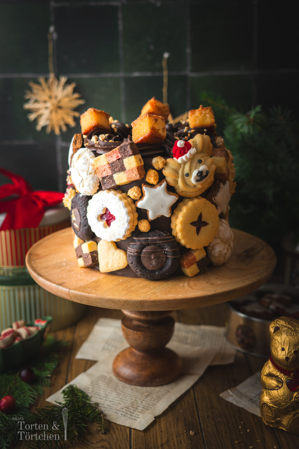 Eine festliche Torte im Germknödel-Stil mit Mohnböden, cremiger Vanillesauce, fruchtigem Pflaumenmus und einer edlen Schokoladenganache. Verziert mit Weihnachtsplätzchen – ideal, um Gäste zu begeistern oder Plätzchenreste kreativ zu verwerten. #Weihnachtstorte #Weihnachtsbäckerei #Backen #Rezept #Weihnachtsplätzchen #Plätzchen