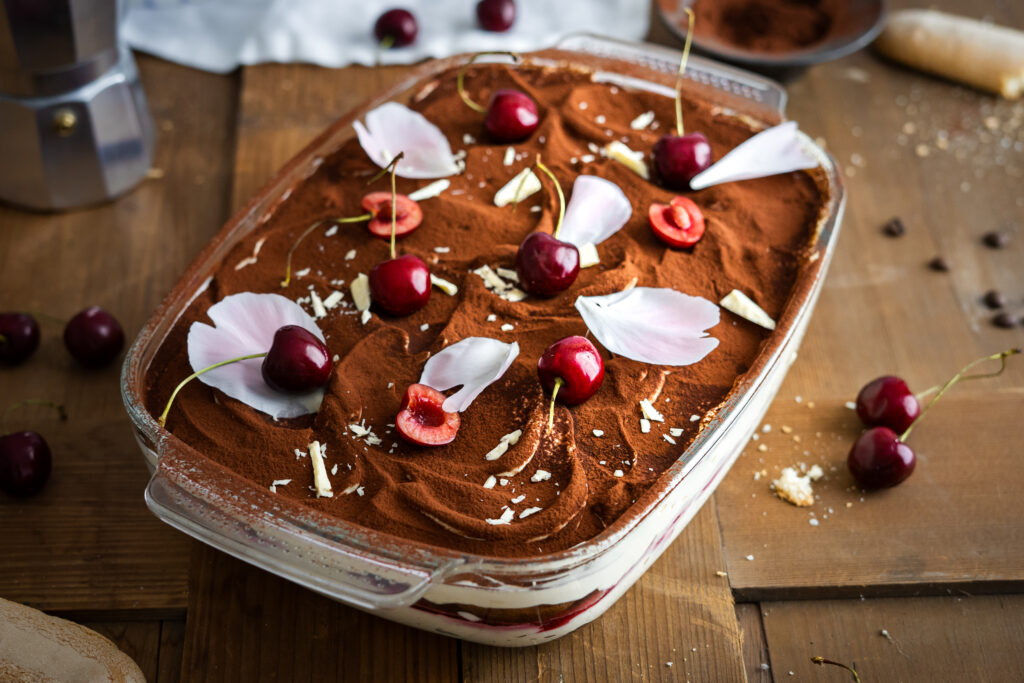 Dieses Sauerkirsch-Tiramisu vereint fruchtiges Kirschkompott, cremige Mascarpone und aromatischen Espresso zu einem sommerlichen Dessertklassiker mit Twist. Ob mit selbstgemachten oder gekauften Löffelbiskuits – das Rezept gelingt einfach, lässt sich gut vorbereiten und schmeckt am nächsten Tag sogar noch besser. #Tiramisu #Rezept #Backen #Löffelbiskuit #Kirschen #Dessert