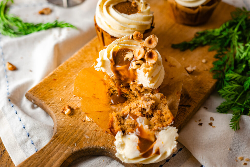 Dieses Karotten Cupcakes Rezept mit Karamellfüllung kombiniert saftigen Rührteig, aromatische Gewürze und die natürliche Süße frischer Karottenraspeln. Die gefüllten Cupcakes sind einfach zuzubereiten und bringen mit ihrer cremigen Karamellnote eine besondere Raffinesse in jedes Dessert. Ob für den Herbst, Winter oder als besonderes Highlight zum Kaffee, diese Karottenkuchen Cupcakes sind die perfekte Wahl für alle, die saftige Cupcakes mit Füllung lieben. #Karottenkuchen #Karamell #Zimt #Carrotcake #Cupcakes #Rübli #backen #Rezept