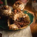 Rezept für winterliche Nougat Cupcakes mit einem saftigen Schokoladenmuffin mit Malzbier, einer Füllung aus Nougat, feiner Orangenschale und aromatischem Lebkuchengewürz und einer seidigen Nougatcreme fürs Topping. Perfekt für die Weihnachtsbäckerei und Adventszeit. #backen #Weichnachten #Weihnachtsbäckerei #Cupcakes #Nougat