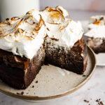 Ein einfaches Rezept für einen super saftigen und fudgy Heiße Schokoladen Kuchen. Der Boden ist wie ein Mix aus Brownie und Schokokuchen, oben drauf kommt eine samtige Schokoladen Ganache, bevor alles von flambiertem Baiser getoppt wird. #Schokoladenkuchen #Heißeschokolade #backen #Ganache #Schokolade #Baiser