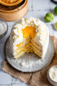 Mango Sticky Rice Torte inspiriert vom beliebten Thai Dessert. Luftiger Kokosbiskuit, cremige Kokos Mascarpone, fruchtiges Mangokompott und authentischer Sticky Rice sorgen für eine besonders saftige, cremige und exotische Torte. Perfekt für den Sommer! #mangotorte #mangostickyrice #kokostorte #tortenrezept #sommertorte #dessert #backen #geburtstagstorte #mango #kokos #thaidessert #backliebe