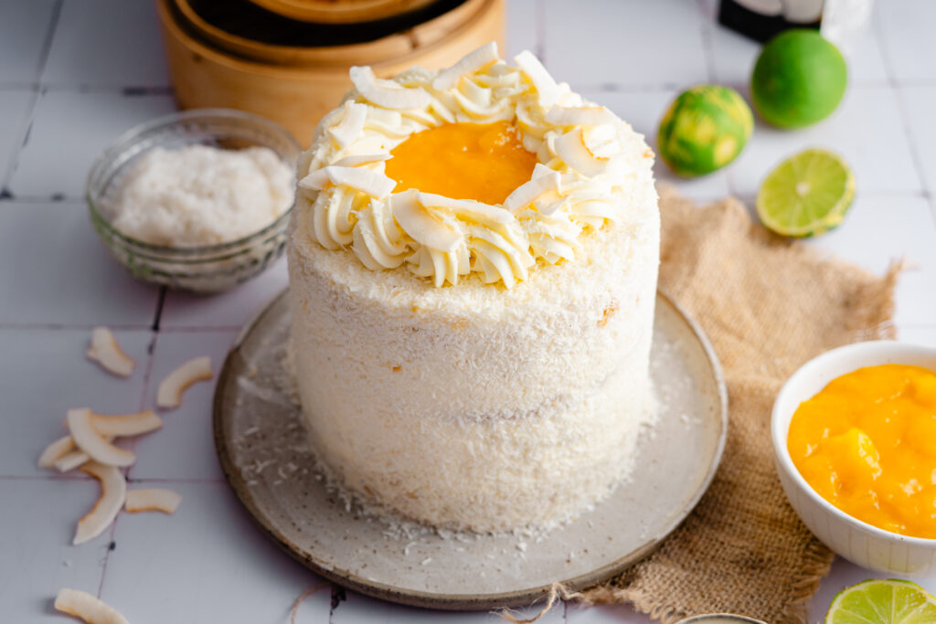 Mango Sticky Rice Torte inspiriert vom beliebten Thai Dessert. Luftiger Kokosbiskuit, cremige Kokos Mascarpone, fruchtiges Mangokompott und authentischer Sticky Rice sorgen für eine besonders saftige, cremige und exotische Torte. Perfekt für den Sommer! #mangotorte #mangostickyrice #kokostorte #tortenrezept #sommertorte #dessert #backen #geburtstagstorte #mango #kokos #thaidessert #backliebe