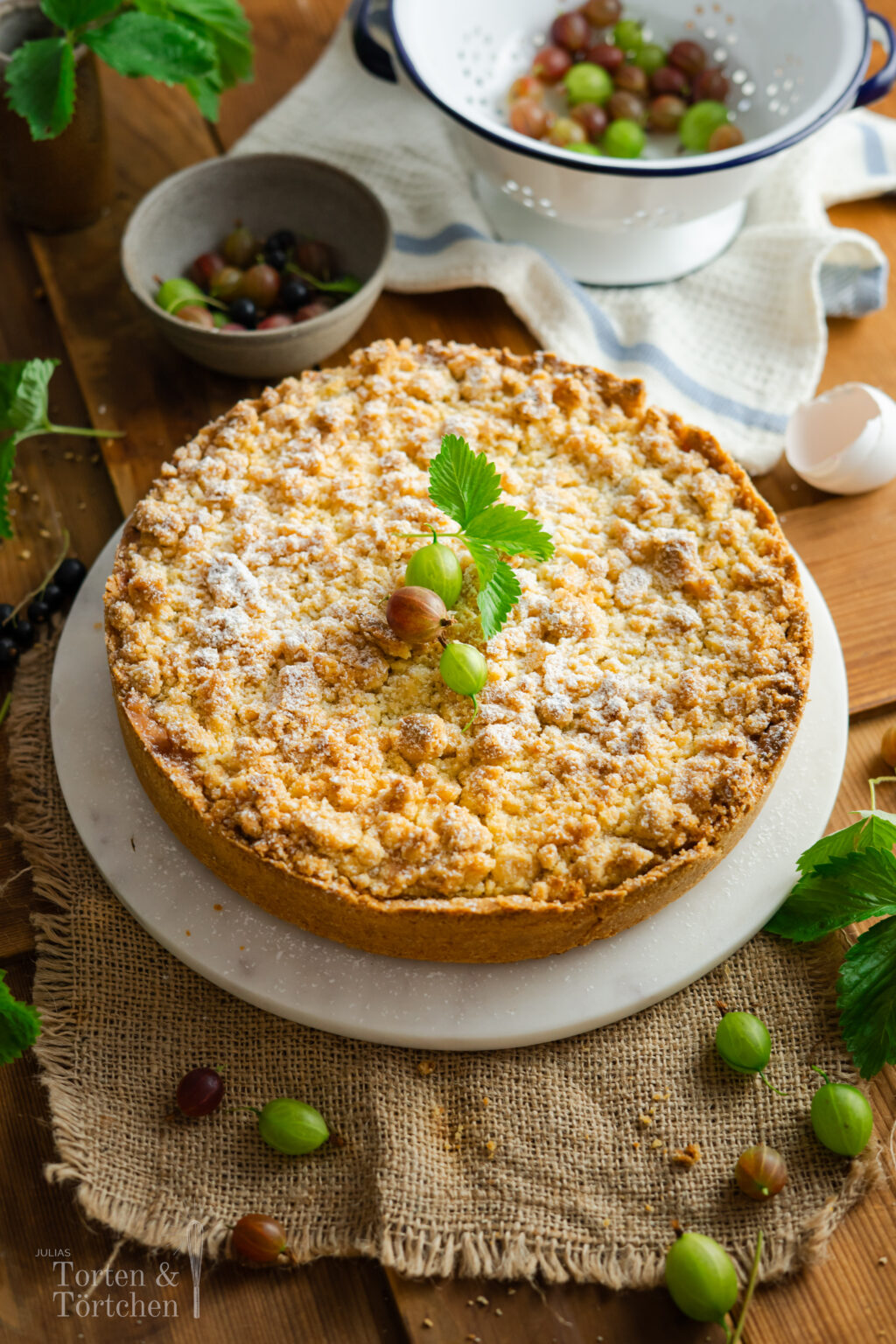 Stachelbeer Streuselkuchen mit cremiger Vanillepuddingfüllung, frischen Stachelbeeren und buttrigen Streuseln. Ein einfacher, saftiger Obstkuchen mit knuspriger Decke und fruchtig-säuerlicher Füllung, perfekt für den Sommer und wenn man mal zu viele Stachelbeeren geerntet hat! #stachelbeerkuchen #streuselkuchen #obstkuchen #sommerkuchen #puddingkuchen #backen #kuchenrezept #stachelbeeren #kaffeetafel #einfachbacken