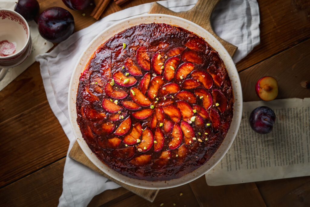 Tonka Pflaumen Upside Down Kuchen mit karamellisierter Pflaumenschicht, weichem Rührteig, Buttermilch, Amaretto und warmen Gewürzen. Ein aromatischer Herbstkuchen mit Zimt, Tonkabohne und saftigen roten Pflaumen, der nach gemütlichen Nachmittagen, goldener Jahreszeit und frisch gebackenem Kuchen duftet. #pflaumenkuchen #upsidedowncake #herbstkuchen #tonkabohne #rührkuchen #backen #kuchenrezept #zimt #amaretto #saisonalesbacken